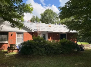 Roofing crew installing new underlayment and attic vents on a brick ranch home in Tennessee